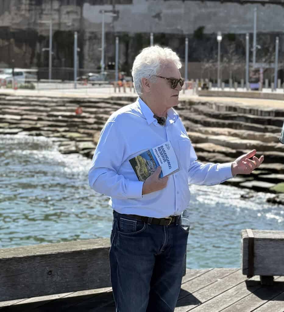 1. Man holding soil and environmental brochure near waterfront.