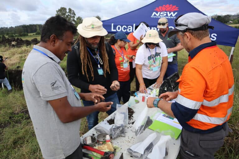 Soil science experts conducting field testing at a rural outdoor site in Australia.